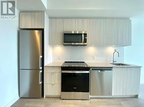 Richmond Hill (South Richvale) condo for rent - A modern kitchen with a refrigerator, oven, and microwave.