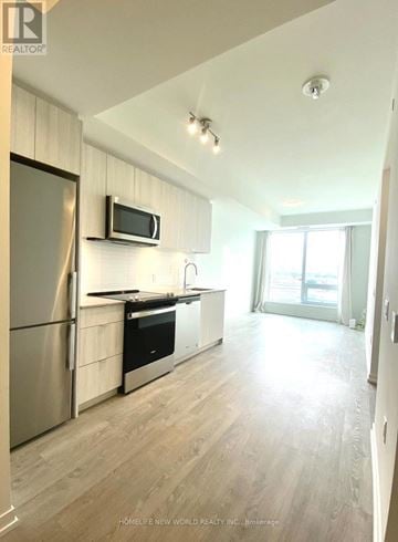 Richmond Hill (South Richvale) condo for rent - A kitchen with a refrigerator, microwave, and stove top oven.
