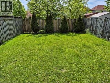 Waterloo apartment for rent - A backyard with a wooden fence and green grass.