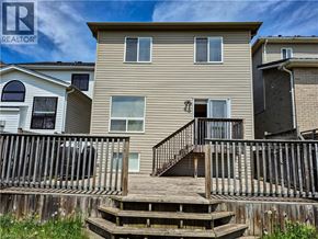 Waterloo apartment for rent - A beige two-story house with a deck in front.