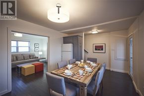 St. John’S apartment for rent - A dining room with a wooden table set for a meal.