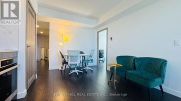 Toronto (Waterfront Communities) condo for rent - A living room with a green couch and a bar stool.