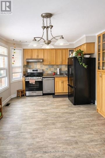 Whitby (Pringle Creek) apartment for rent - A kitchen with a black fridge and wooden cabinets.