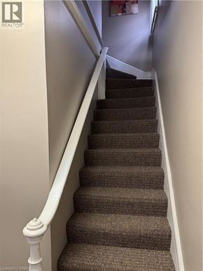 Brantford apartment for rent - A staircase with a white railing and brown carpeted steps.
