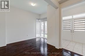 Oshawa (Kedron) apartment for rent - A room with white walls and wooden floors, with a door on the right side.