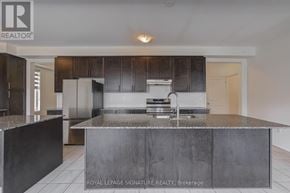 Oshawa (Kedron) apartment for rent - A modern kitchen with dark wood cabinets and a central island.