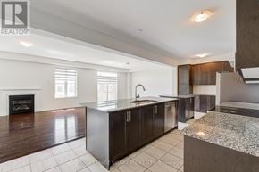 Oshawa (Kedron) apartment for rent - A modern kitchen with a fireplace and a large island.
