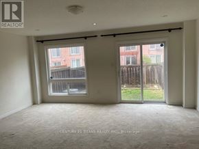 Toronto (Clairlea-Birchmount) townhouse for rent - A room with a sliding door and a window overlooking a fence.