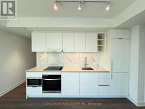 Toronto (Bay Street Corridor) condo for rent - A modern kitchen with white cabinets and appliances.
