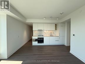 Toronto (Bay Street Corridor) condo for rent - A kitchen area with white cabinets and a wooden floor.