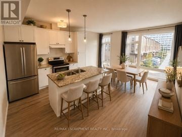Hamilton (Mcquesten) townhouse for rent - A modern kitchen with a dining table and chairs.