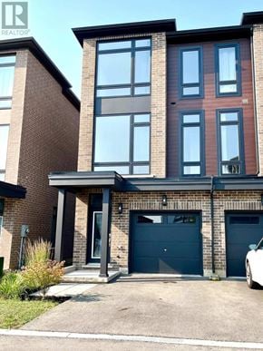 Hamilton (Mcquesten) townhouse for rent - A modern two-story residential building with a garage.