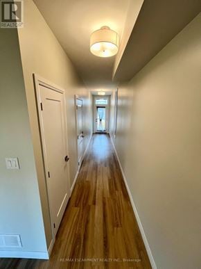 Hamilton (Mcquesten) townhouse for rent - A long hallway with wood floors and white walls.