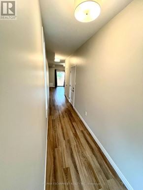 Hamilton (Mcquesten) townhouse for rent - A long hallway with wood floors and white walls.