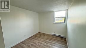 Ottawa condo for rent - A white room with a window and a wooden floor.