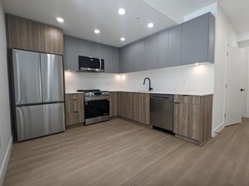 Surrey apartment for rent - A modern kitchen with wooden cabinets and stainless steel appliances.