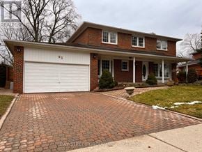 Toronto (St. Andrew-Windfields) apartment for rent - A brick house with a white garage door and a driveway made of bricks.