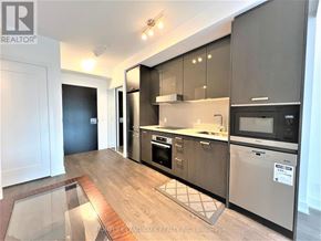 Toronto (Mount Pleasant West) condo for rent - A modern kitchen with dark wood cabinets and stainless steel appliances.