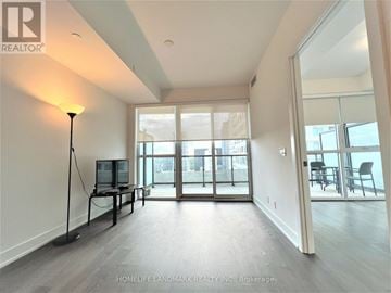 Toronto (Mount Pleasant West) condo for rent - A well-lit, spacious living room with a television and sliding glass doors.