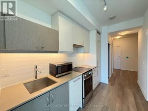 Toronto (Kensington-Chinatown) condo for rent - A kitchen with a sink, stove, and microwave.