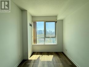 Toronto (Kensington-Chinatown) condo for rent - A room with a large window overlooking a city skyline.