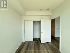 Toronto (Kensington-Chinatown) condo for rent - A room with a white door and a wooden floor.