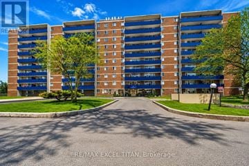 Toronto (Dorset Park) condo for rent - A large, multi-story building with a parking lot in front.