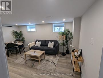 Hamilton (Hill Park) apartment for rent - A living room with a grey couch, a wooden coffee table, and a dining table with chairs.