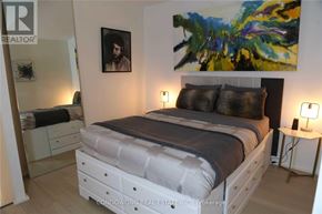 Toronto (Church-Yonge Corridor) condo for rent - A bedroom with a large bed, a painting on the wall, and a mirror on the wall.