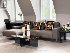 Toronto (Bridle Path-Sunnybrook-York Mills) apartment for rent - A modern living room with a grey couch, a glass coffee table, and a black chair.