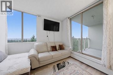 North Vancouver apartment for rent - A living room with a white couch and a flat screen TV mounted on the wall.
