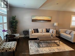 Niagara Falls (Oldfield) apartment for rent - A living room with a couch, chairs, and a painting on the wall.