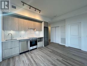 Toronto (Cabbagetown-South St. James Town) condo for rent - A modern kitchen with wooden cabinets and stainless steel appliances.
