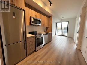Toronto (Dovercourt-Wallace Emerson-Junction) condo for rent - A kitchen with wooden cabinets and stainless steel appliances.