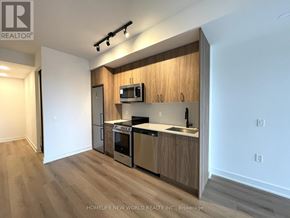 Toronto (Dovercourt-Wallace Emerson-Junction) condo for rent - A kitchen with wooden cabinets and stainless steel appliances.