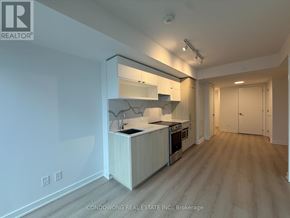 Toronto (Church-Yonge Corridor) condo for rent - A modern kitchen with white cabinets and a wooden island.