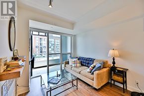 Toronto (Kensington-Chinatown) condo for rent - A living room with a couch, a glass table, and a lamp.