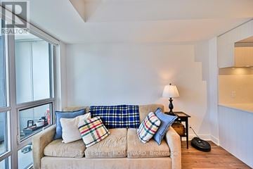 Toronto (Kensington-Chinatown) condo for rent - A living room with a tan couch and a small black table.