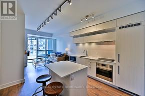 Toronto (Kensington-Chinatown) condo for rent - A modern kitchen with white cabinets and a large island.