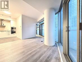 Toronto (Waterfront Communities) condo for rent - A modern kitchen with a large island and a view of the city.