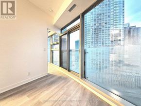 Toronto (Waterfront Communities) condo for rent - A room with a view of a cityscape through large windows.