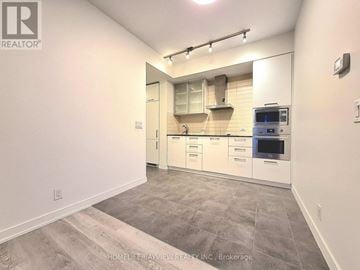 Toronto (Waterfront Communities) condo for rent - A kitchen with white cabinets and a tile backsplash.