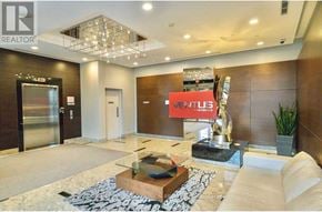 Toronto (Agincourt South-Malvern West) condo for rent - A reception area with a white sofa, a glass coffee table, and a large chandelier.