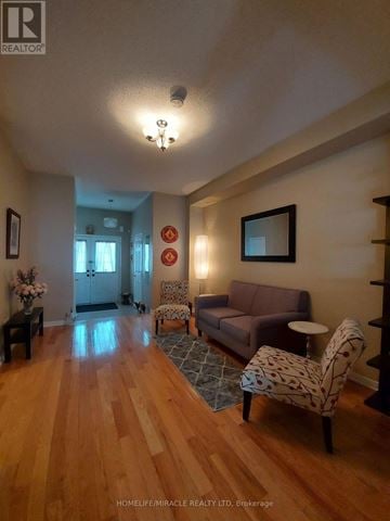 Halton Hills (Georgetown) townhouse for rent - A living room with a brown couch and a wooden floor.