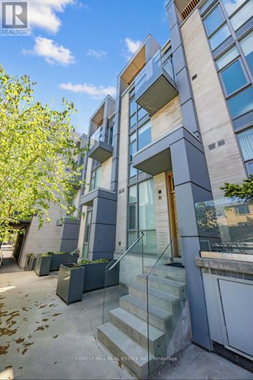 Toronto (Niagara) townhouse for rent - A modern building with a glass entrance and a tree in front.