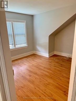 Hamilton (Stoney Creek) triplex for rent - A room with wooden flooring and a window with blinds.