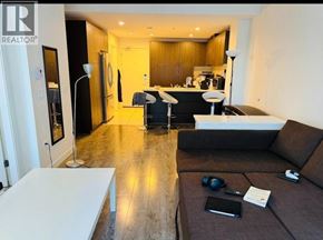 Vancouver apartment for rent - A modern living room with a brown couch and a white coffee table.