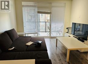 Vancouver apartment for rent - A living room with a black couch and a television.