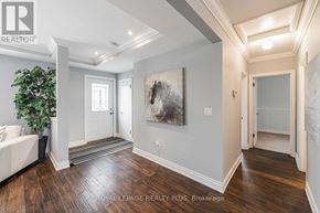 Hamilton (Waterdown) apartment for rent - A spacious room with a large painting on the wall and a plant in the corner.