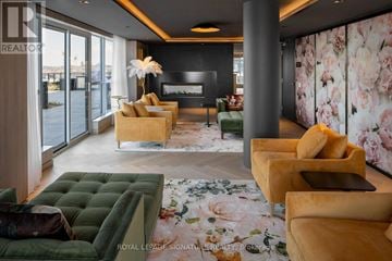 Oakville (Go Glenorchy) condo for rent - A living room with a green sofa and a fireplace.